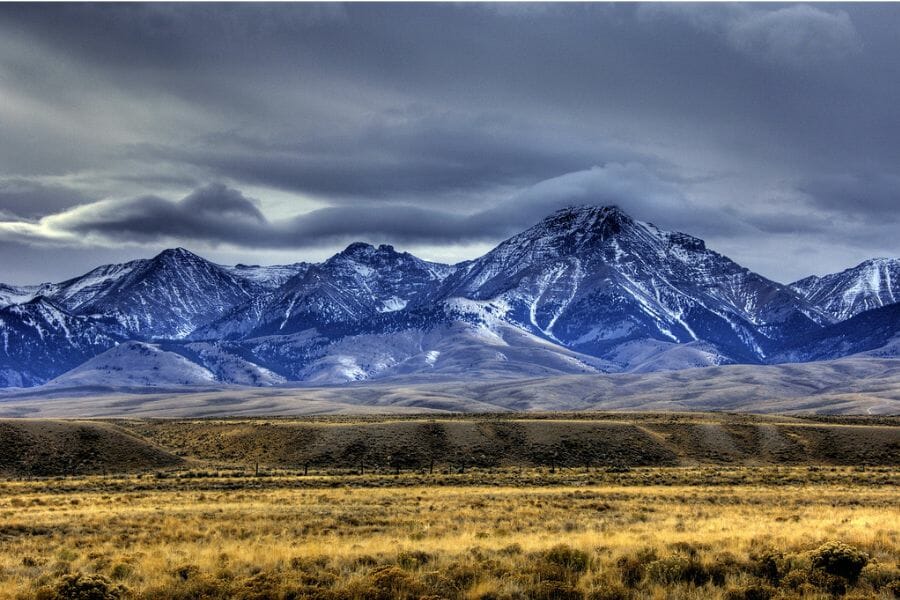 A vast picturesque landscape of Bighorn Mountain with snowy mountain ranges and grasslands