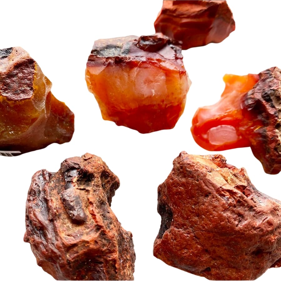 Different pieces of raw carnelians showing different shades of orange, red, and brown