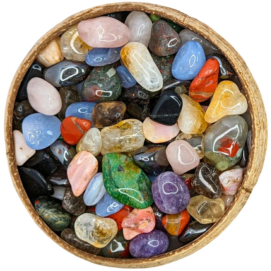 Different cut and polished crystals on a wooden bowl