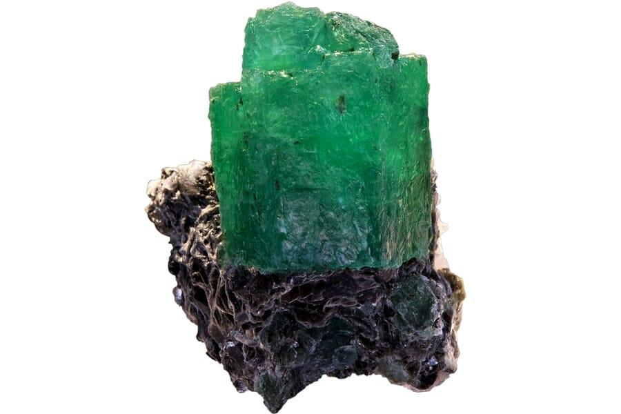 A brilliant piece of rough and natural emerald mineral with a matrix at the bottom