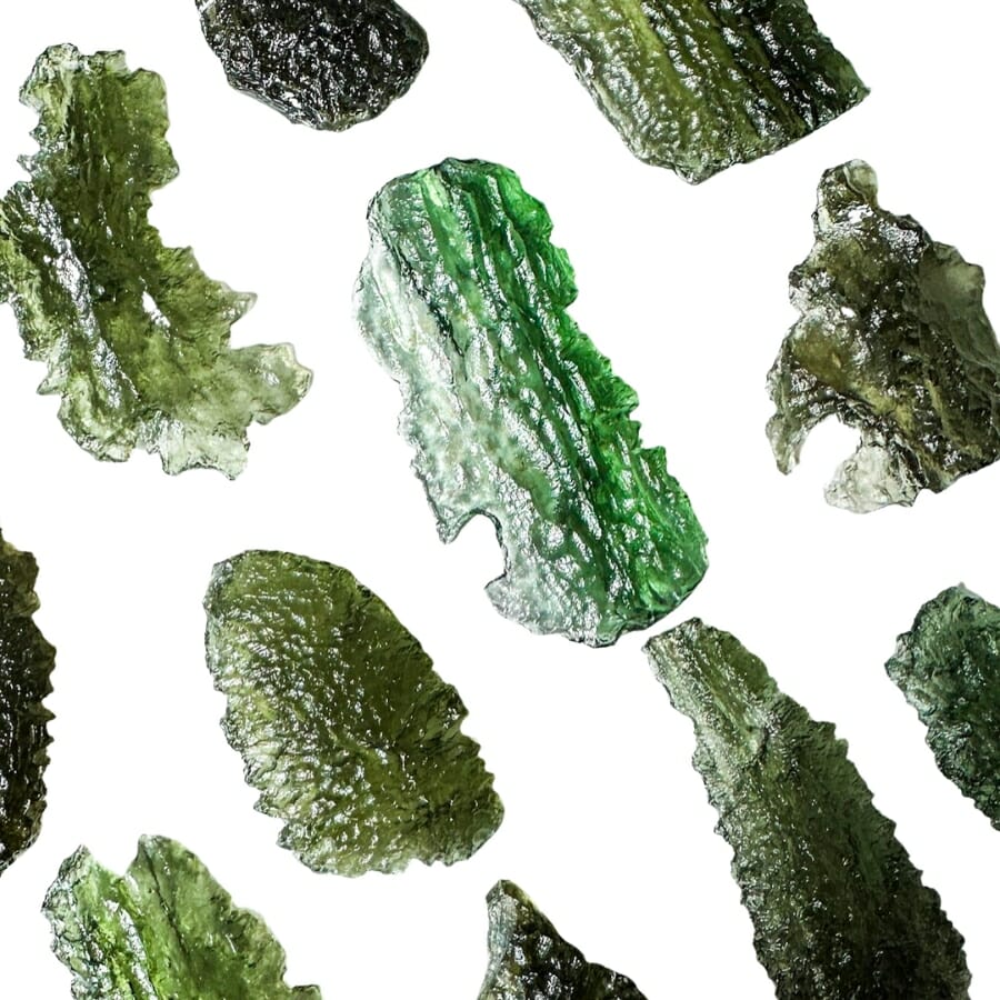 Pieces of differently-shaped moldavite on white background