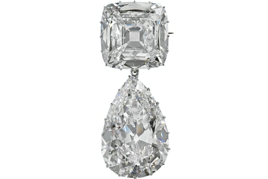 A brooch with two sparkling pear and square-shaped white diamonds