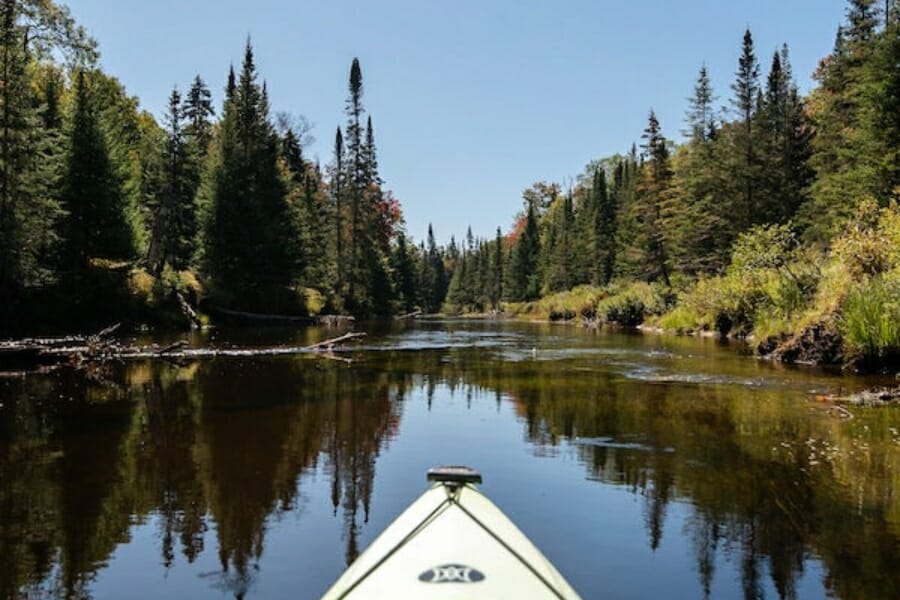 A picturesque view of the Natural Bridge at the lake with forests of trees