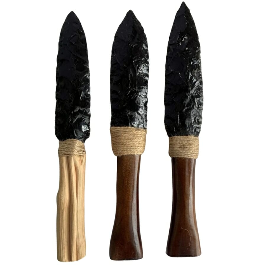 Three different pieces of carved obsidian knives with wooden handles