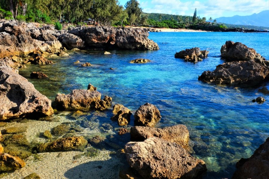 blue ocean waters and beach rocks