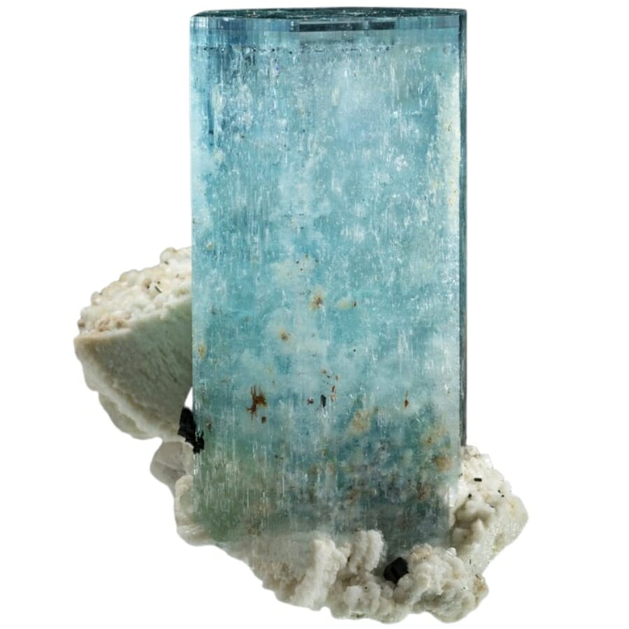 A raw aquamarine on a white albite matrix