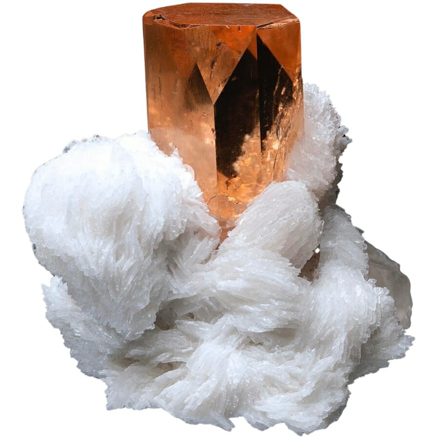 A single crystal of brownish orange topaz on white cleavelandite