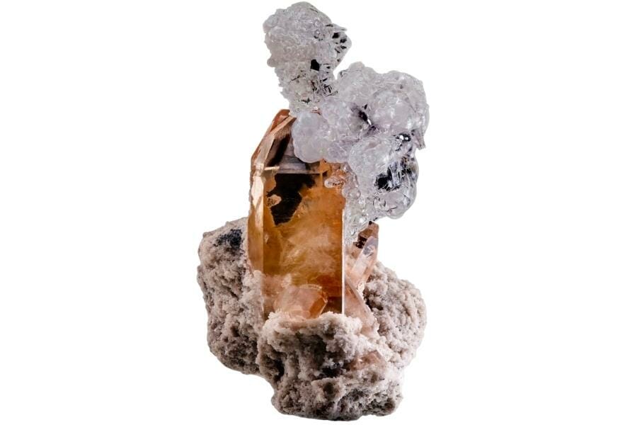 A very unusual pairing hyalite on a cognac-colored topaz crystal in rhyolite