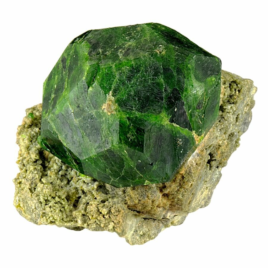 rough bright green demantoid garnet on a rock