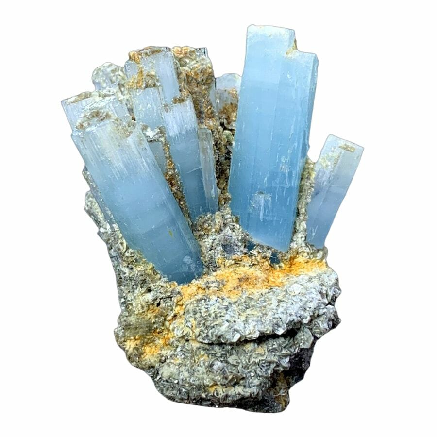 several bright sky blue aquamarine crystals clustered together on a rock
