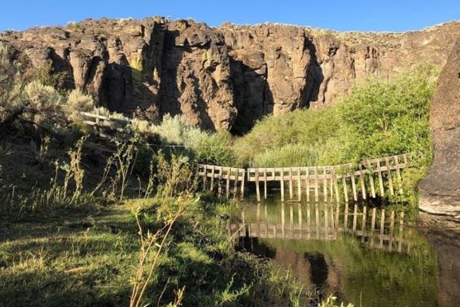 A majestic formation and a fence built through the creek