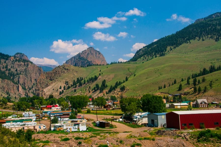 buildings in a town with green mountain slopes in the background