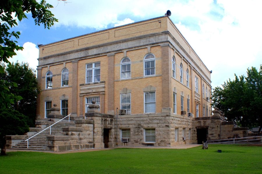 tan brick building on a green lawn