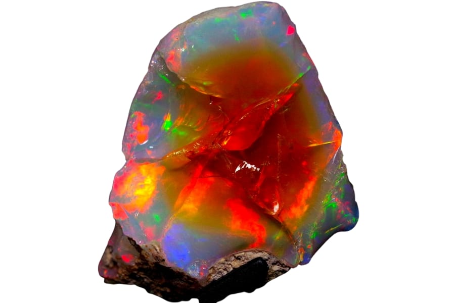 A vibrant rough opal showing intense colors of orange and red in the middle and strikes of blue and green on the side