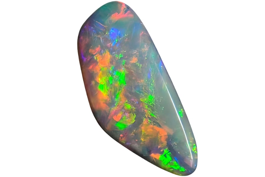 A cut and polished opal with vibrant flashes of green, orange, purple, and blue