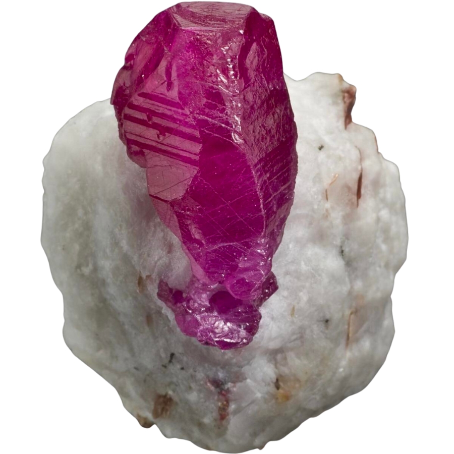 A well-formed, lustrous ruby with a saturated red hue on a marble matrix