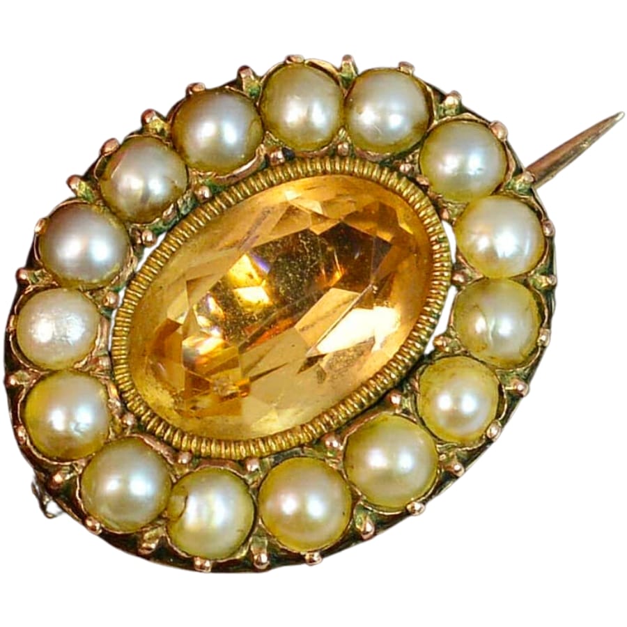 A brooch with a Georgian-period yellow topaz center stone surrounded by lovely pearls