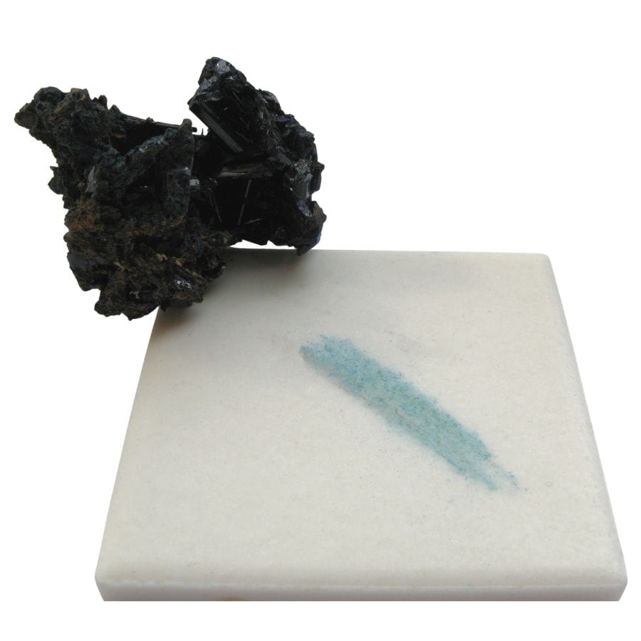 rough azurite showing its blue streak on a white tile