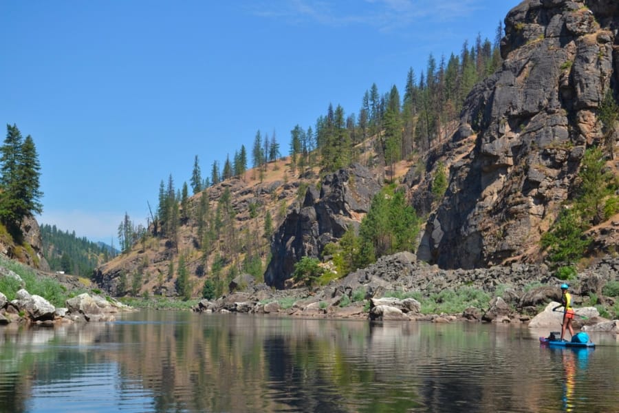 Scenic view of Clearwater River with its surrounding landscapes and a person on a kayak