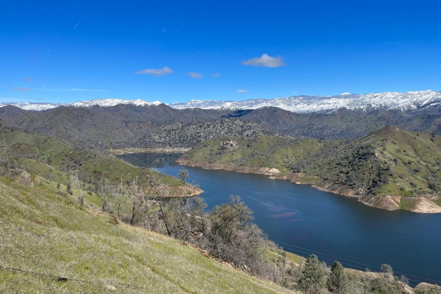 An aerial view of the landscape of Hog Mountain with a lake at the center and snow caps on its peaks