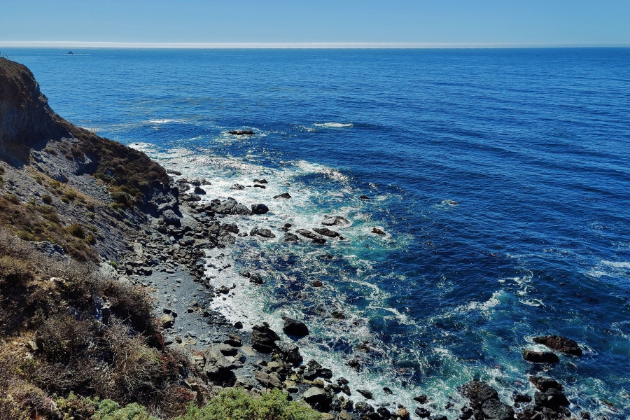 The rocky shores and heavy splashes of waves at Jade Cove with pretty blue waters