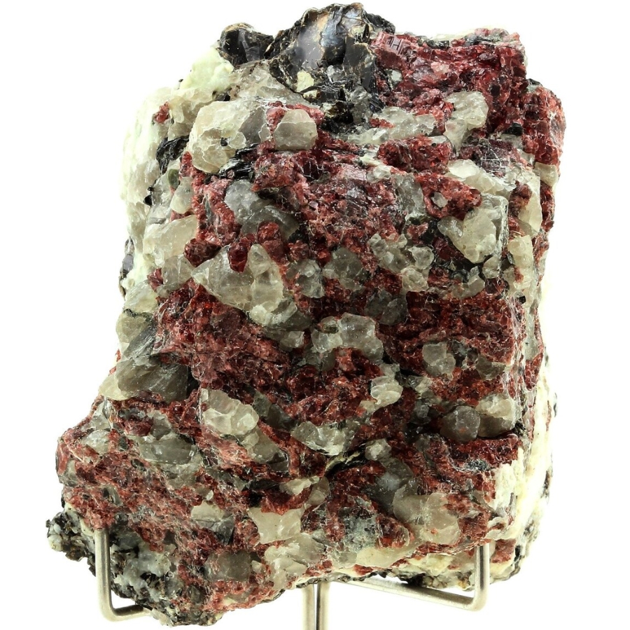 A specimen with dark red pyrope garnets along with biotite, quartz, and calcite