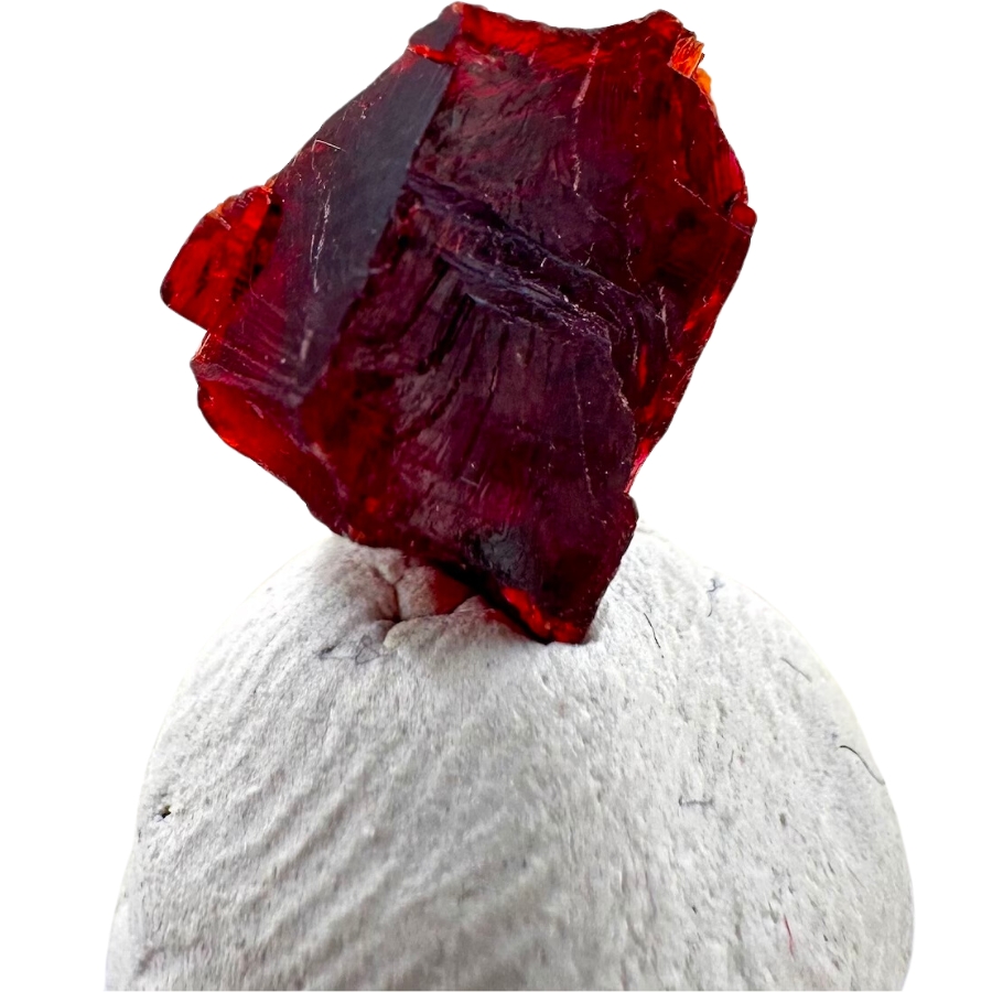A dark red crystal of villaumite atop a white rock