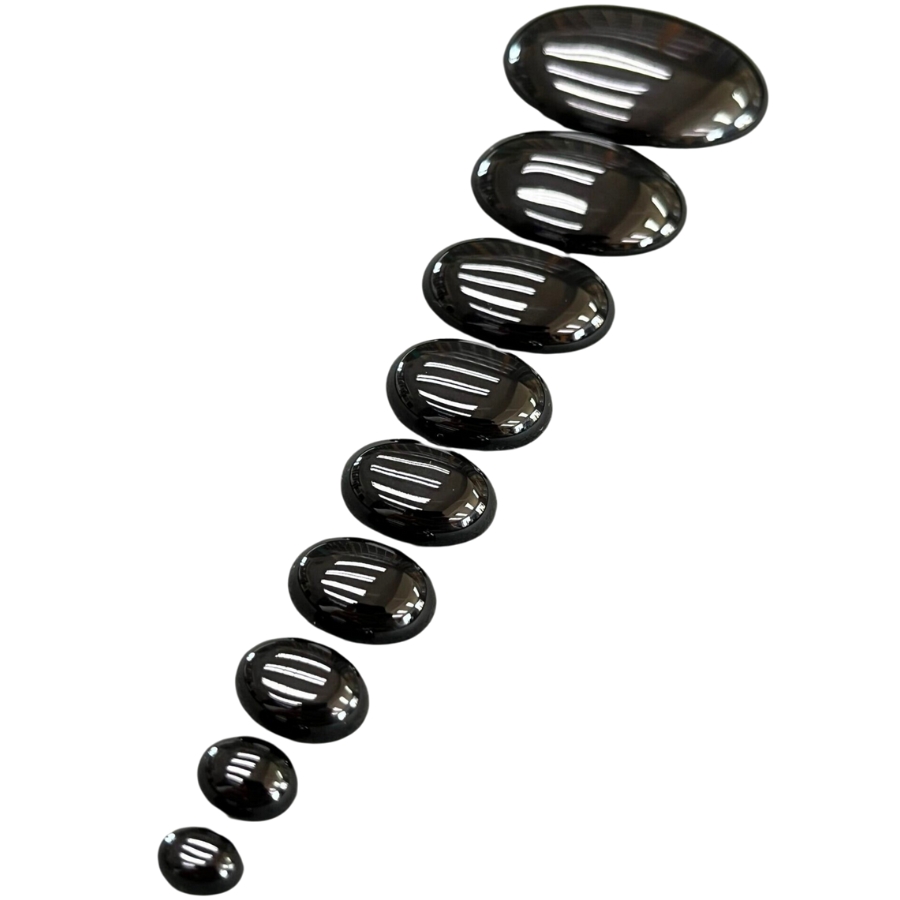 Several black onyx cabochons lined up by size