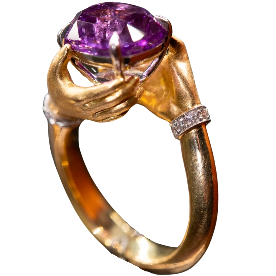 A shiny purple sapphire set as a center stone to a beautiful golden ring