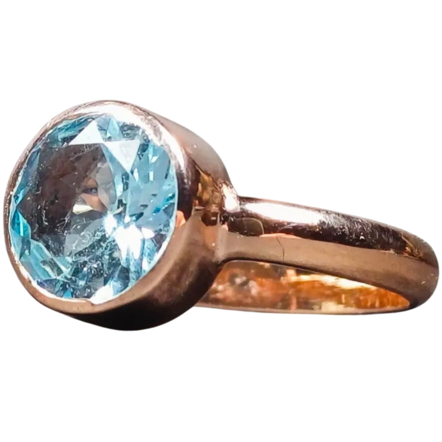 A rose gold-plated silver ring with a shiny, round sky blue topaz as center stone