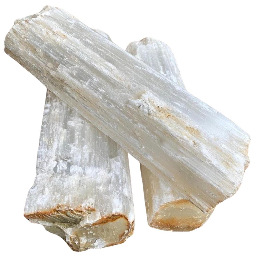 three rough white selenite logs