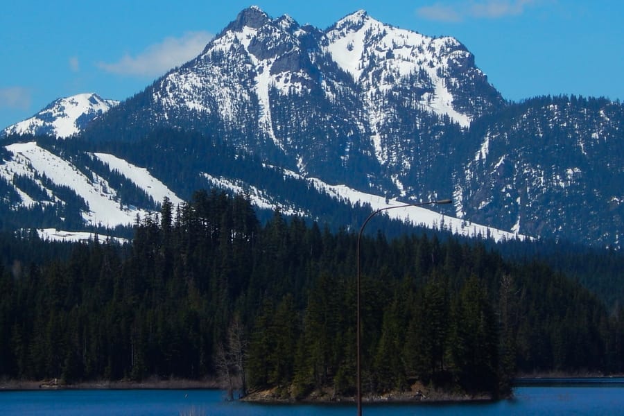 Snowy slopes of Denny Mountain foregrounded with a lake