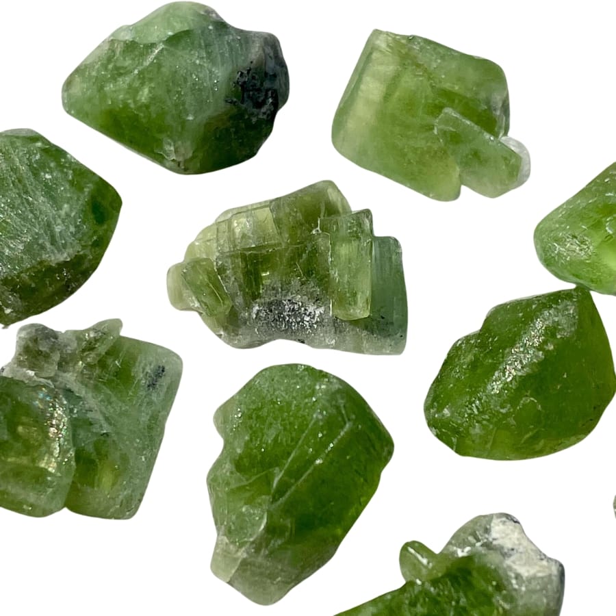 Several raw peridot crystals with different shades of green