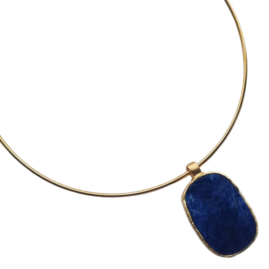 A gold necklace with a deep blue sodalite pendant