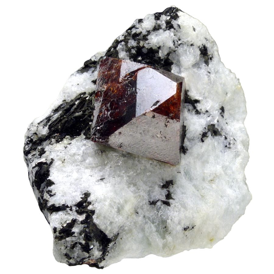 cubic deep red zircon crystal on a rock