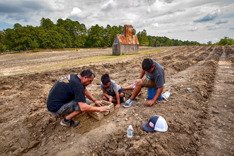 A father and his two sons digging for diamonds at the Crater of Diamonds State Park