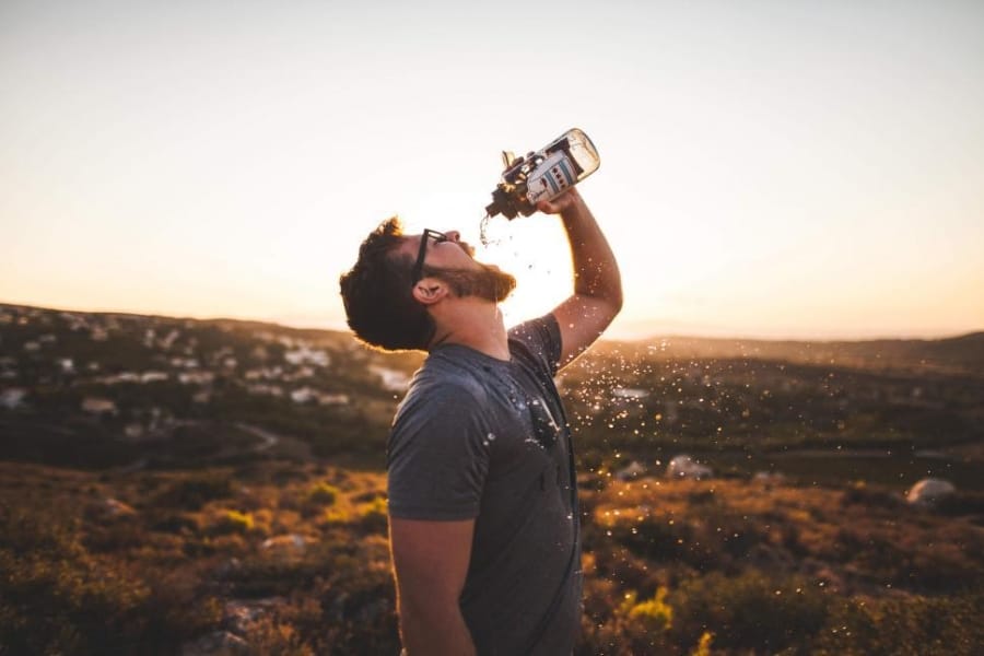 A guy drinking from a bottle
