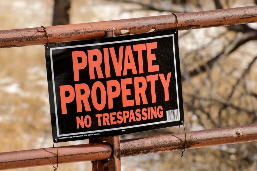 A clear signage with the text, "Private Property No Trespassing" posted on the fence