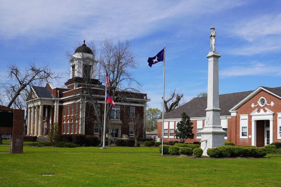 two red brick buildings on a green lawn