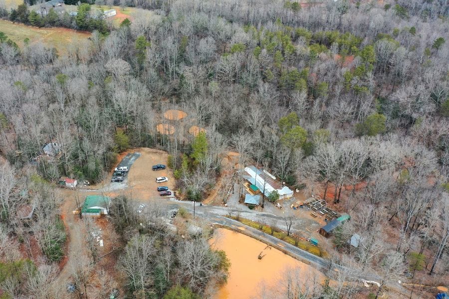 aerial view of a forest, buildings, and cars