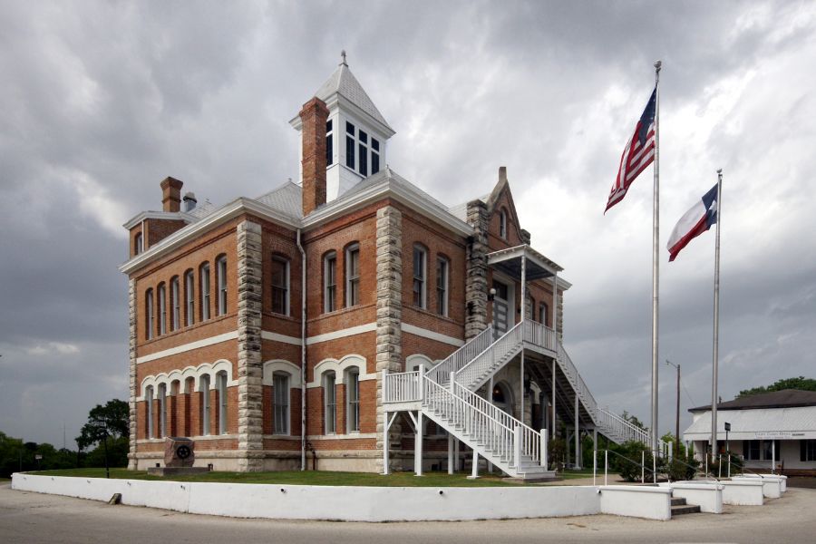 large red brick building with flag poles in front