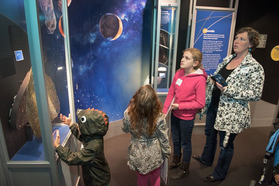 people standing in a museum looking at a display