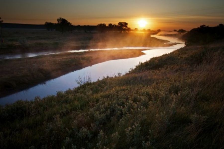 sun rising over a river