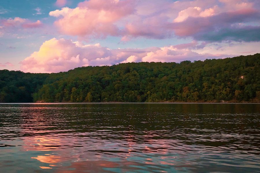 sunset over a lake a tree-lined shore