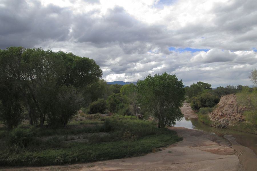 river in an arid valley under a cloudy sky