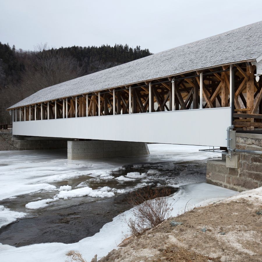 covered bridge over a frozen river