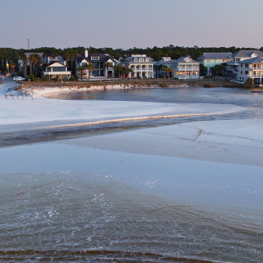 wide sandy beach with houses on the horizon