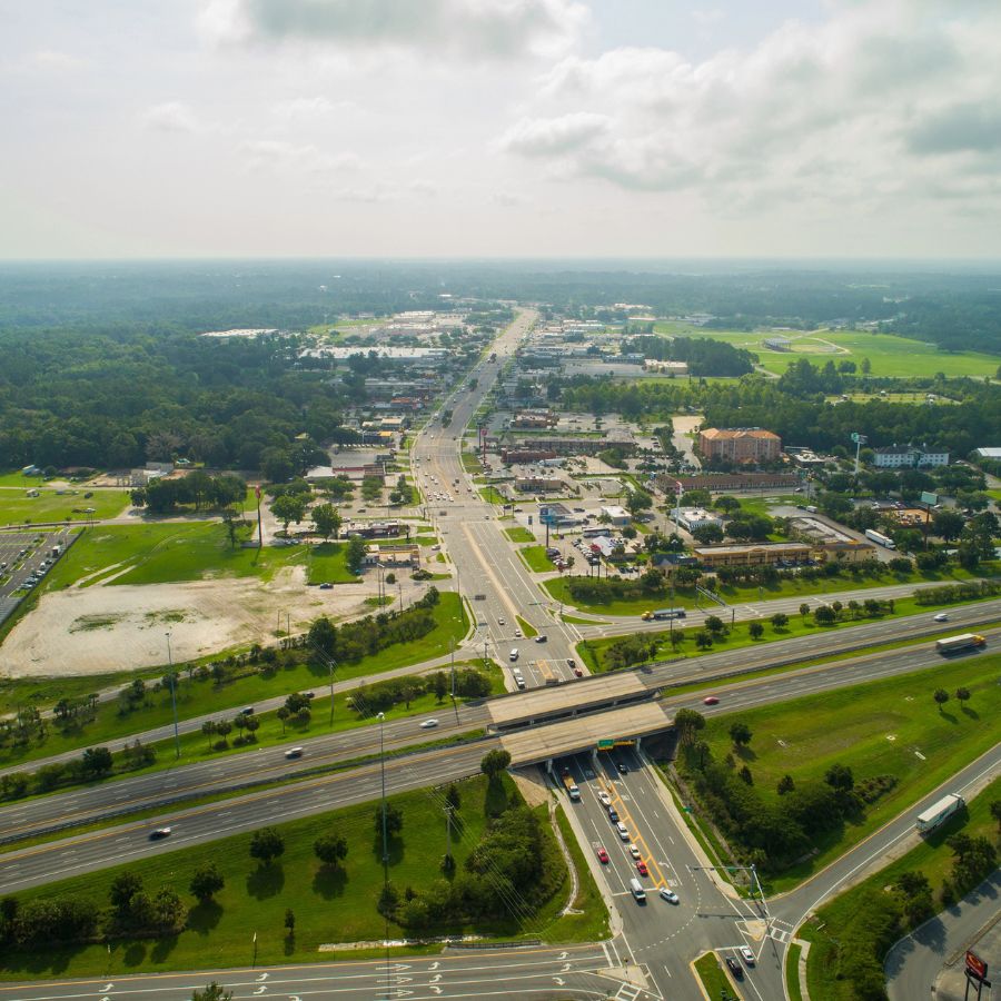 aerial view of roads, buildings, and green grassy fields