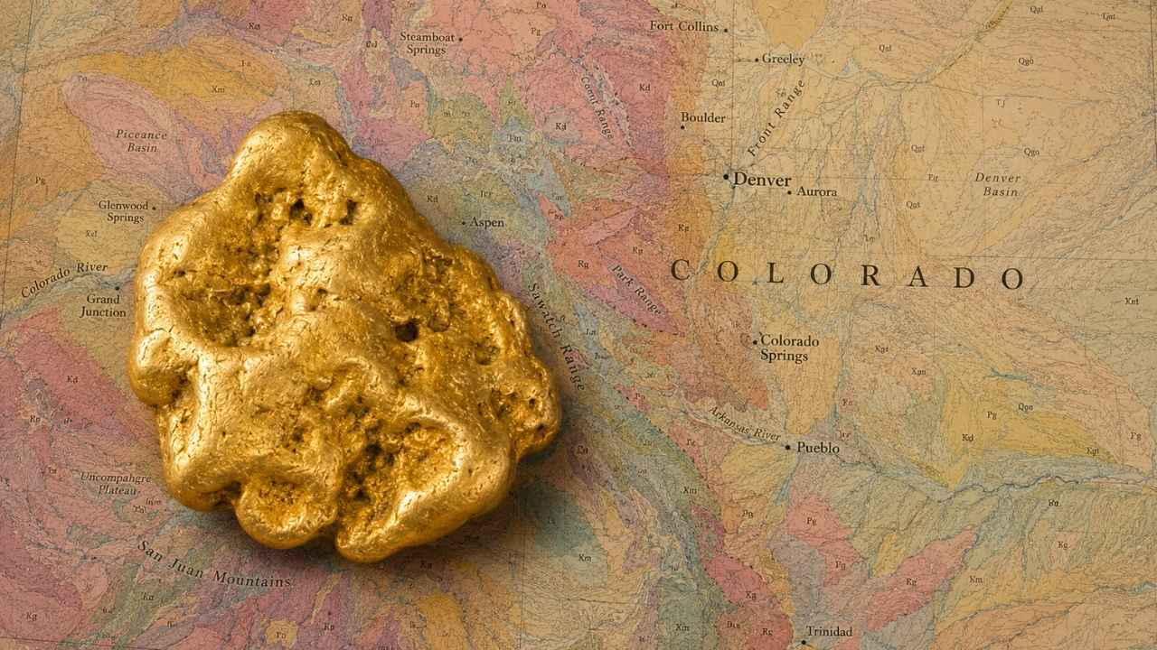 Gold nugget resting on a geological map of Colorado